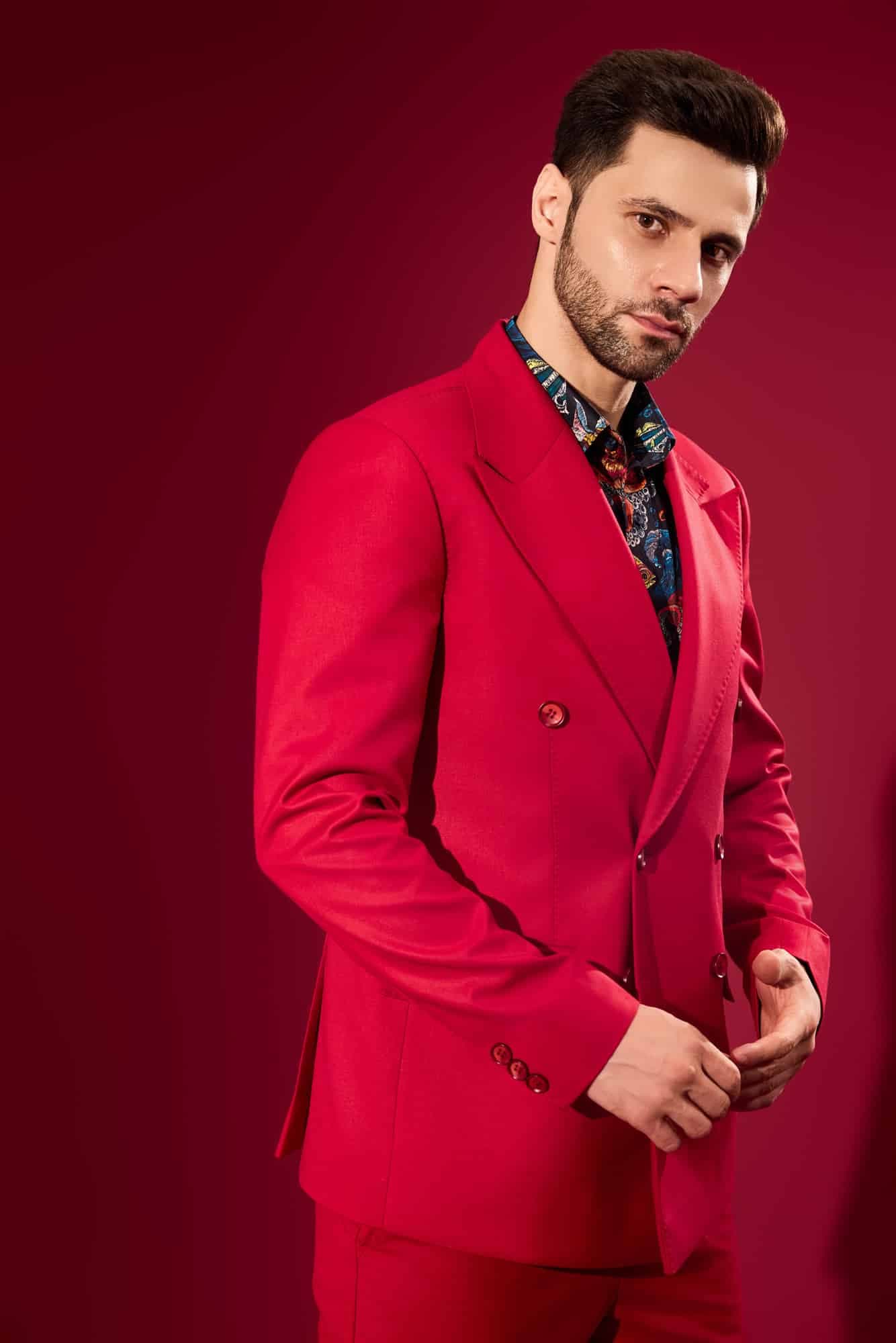 Male model in a red double-breasted suit on a crimson backdrop