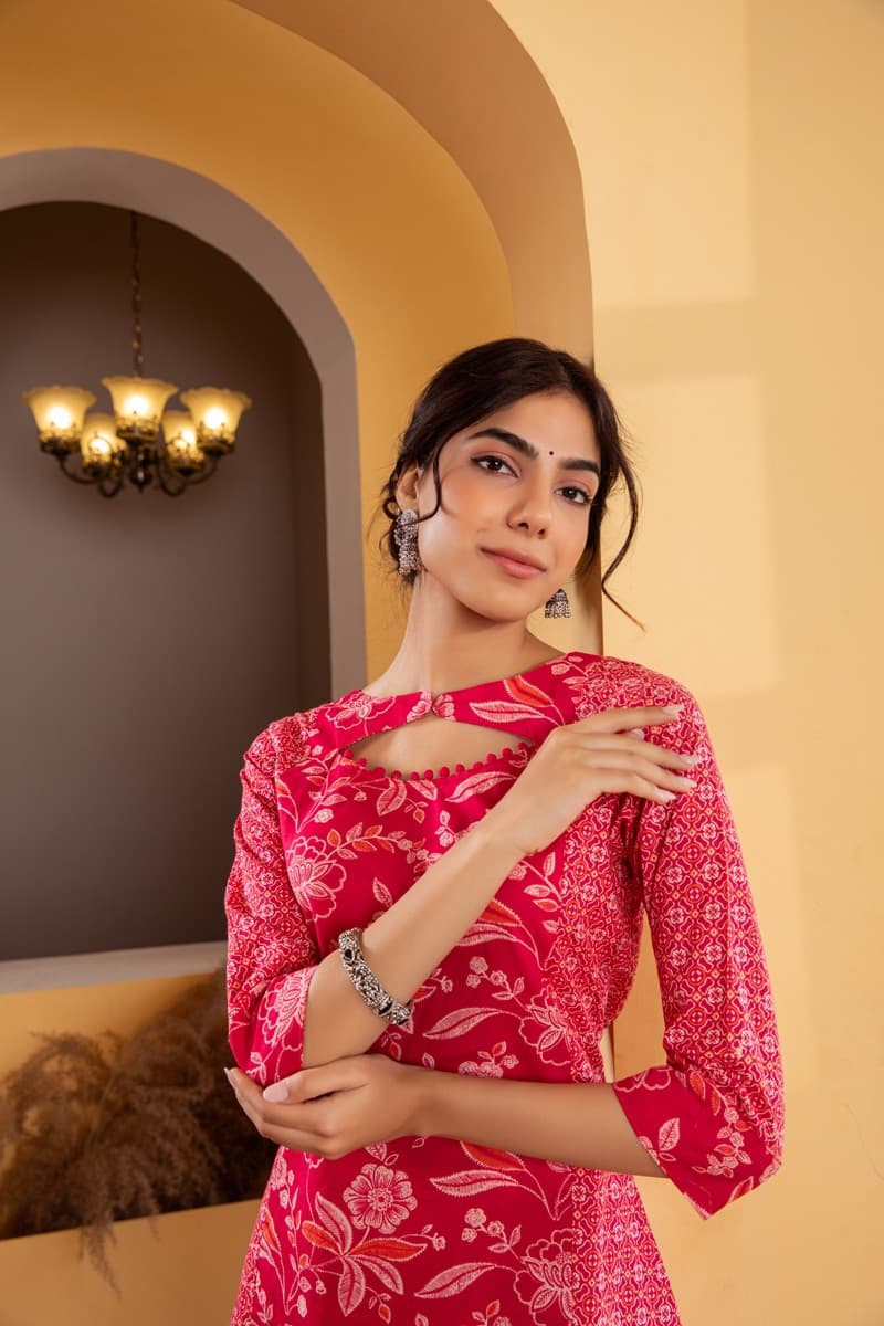 Model in a pink printed outfit under a warm arched alcove