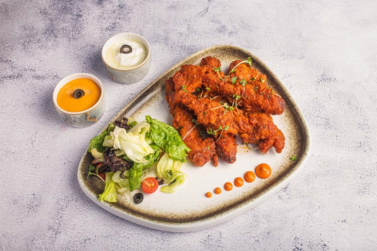 Grilled chicken plated with salad and dips — hospitality photography by Imagesque, Dubai
