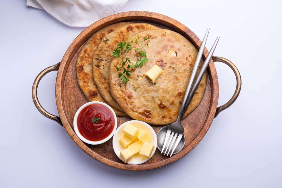 Stuffed paratha with butter and ketchup — hospitality photography by Imagesque, Dubai