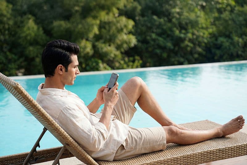 Man reading on a poolside lounger at a luxury villa