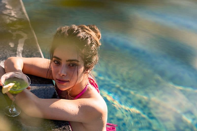 Woman with a cocktail at the edge of a pool — luxury lifestyle photography Dubai