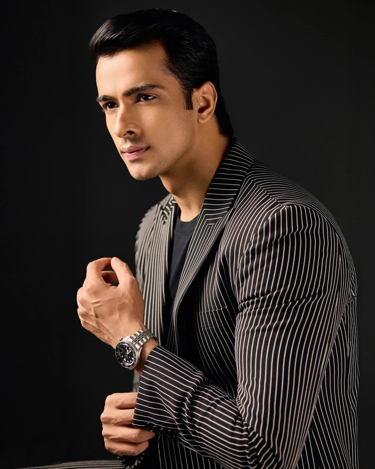 Male model in a pinstripe blazer on a black studio backdrop — model portfolio photography Dubai
