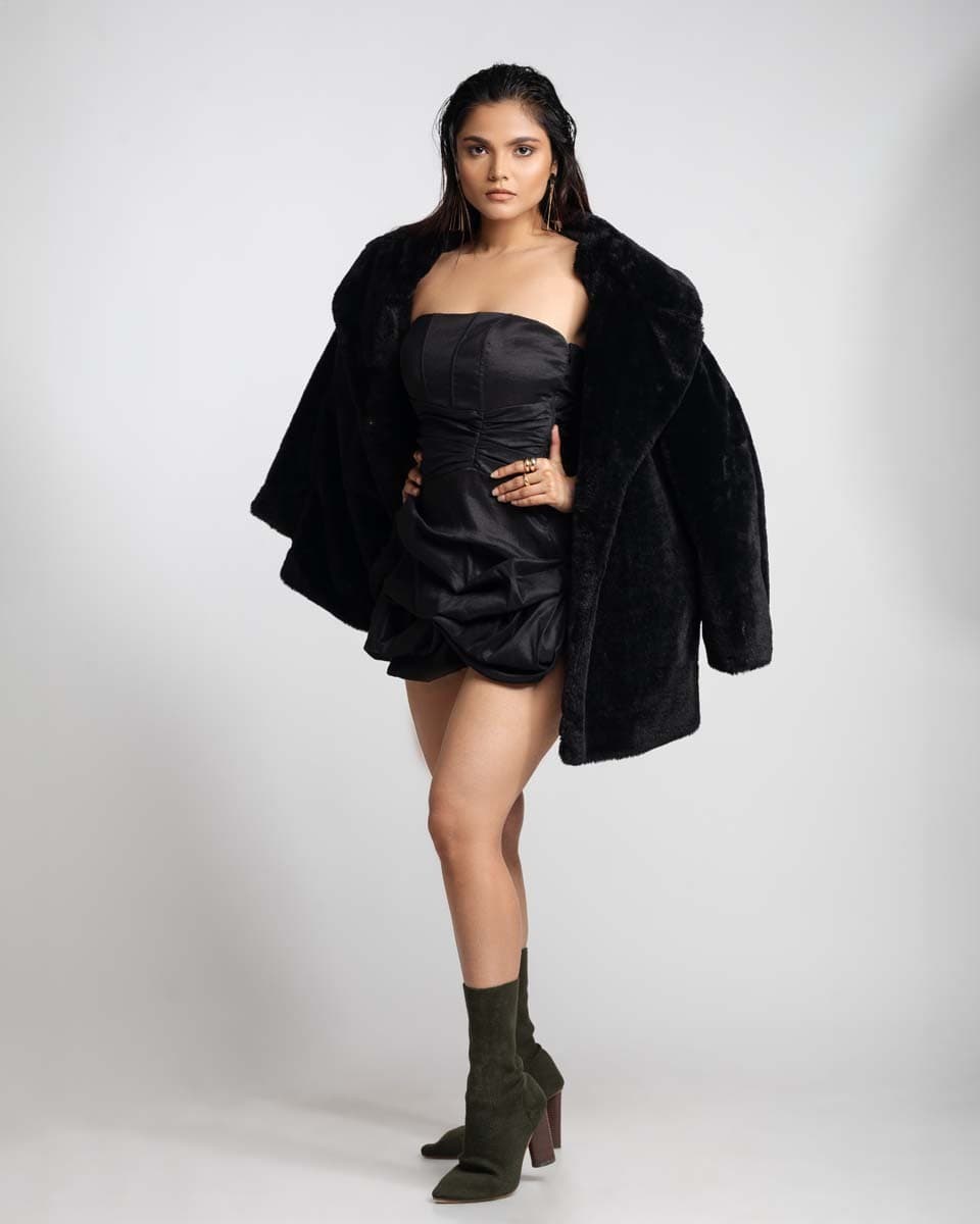 Model in a black mini dress and faux-fur coat, full-length studio portfolio shot