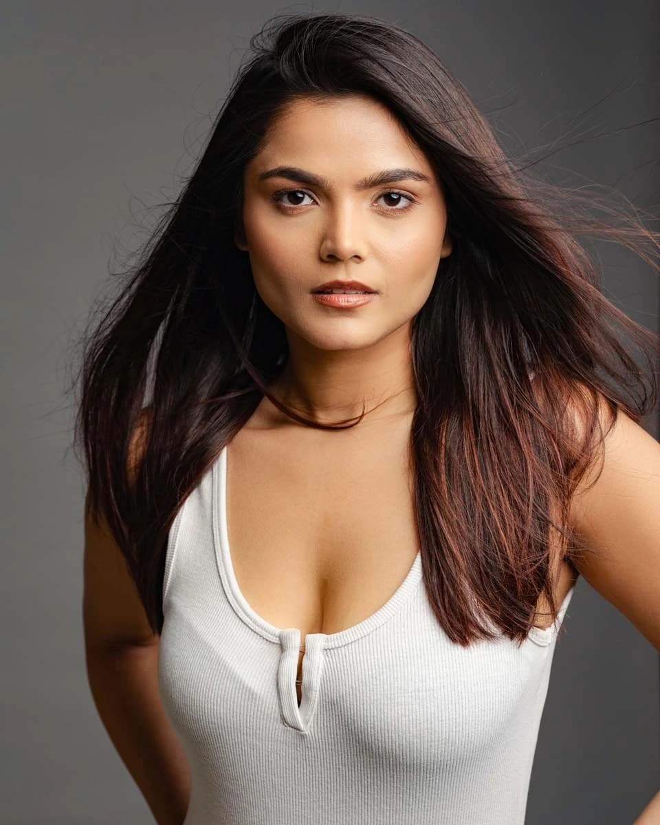 Model portfolio headshot in a white ribbed top against a grey backdrop