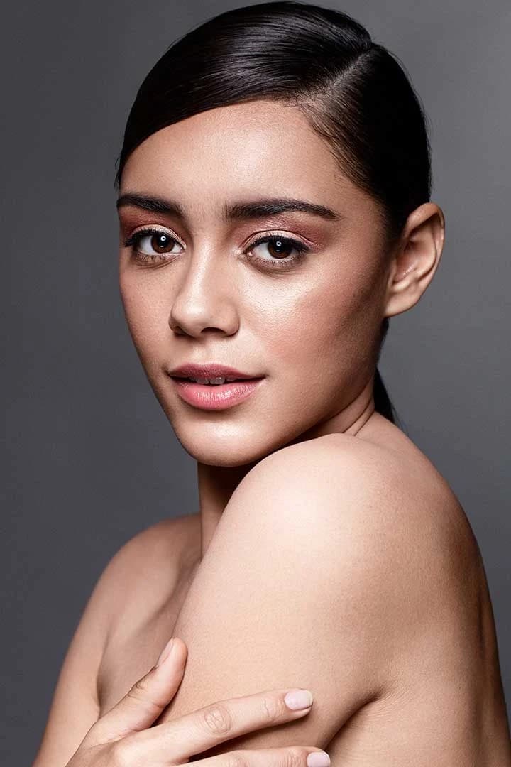 Beauty close-up of a model with sleek hair on a grey studio backdrop